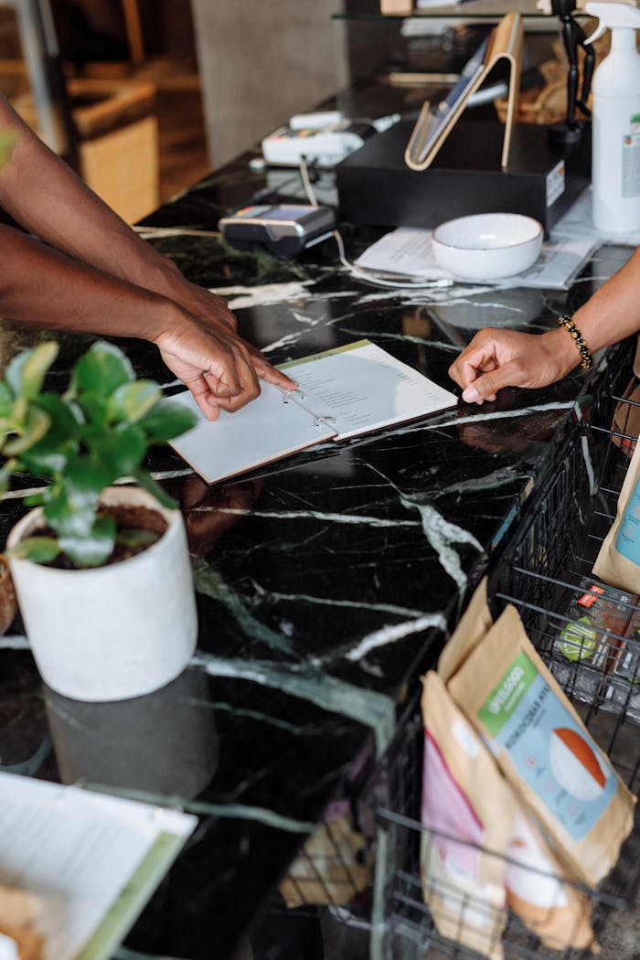 Customers at a modern store counter reviewing a menu and purchasing items.